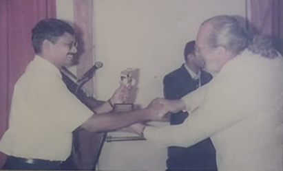 A photo from the National Award For Excellence In Screen Printing 2002, showing Mr. Indrajith, Rhanos' Managing Director receiving a trophy from the legendary Art Screen printer Michel Caza.